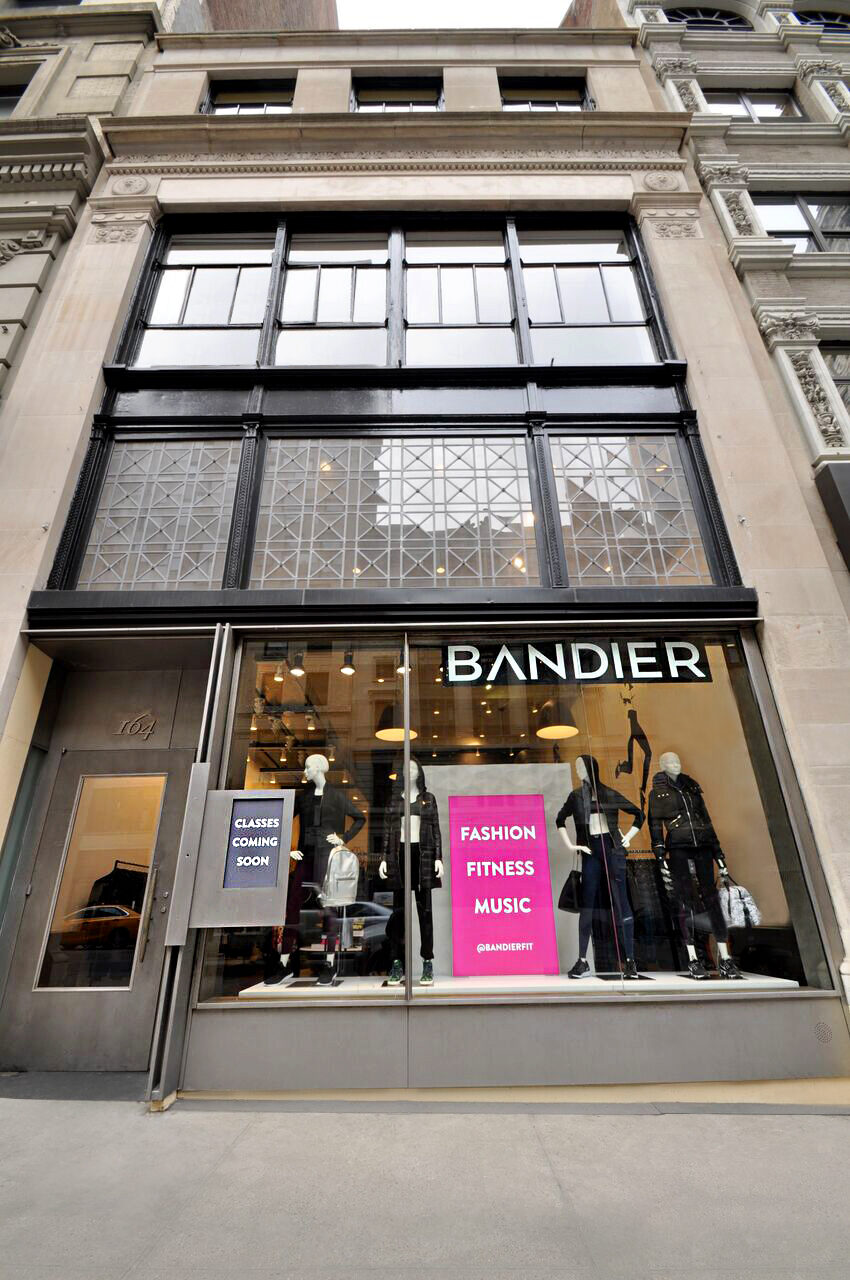 Bandier 5th Ave storefront with tall windows, mannequins, and the Bandier sign above the entrance.