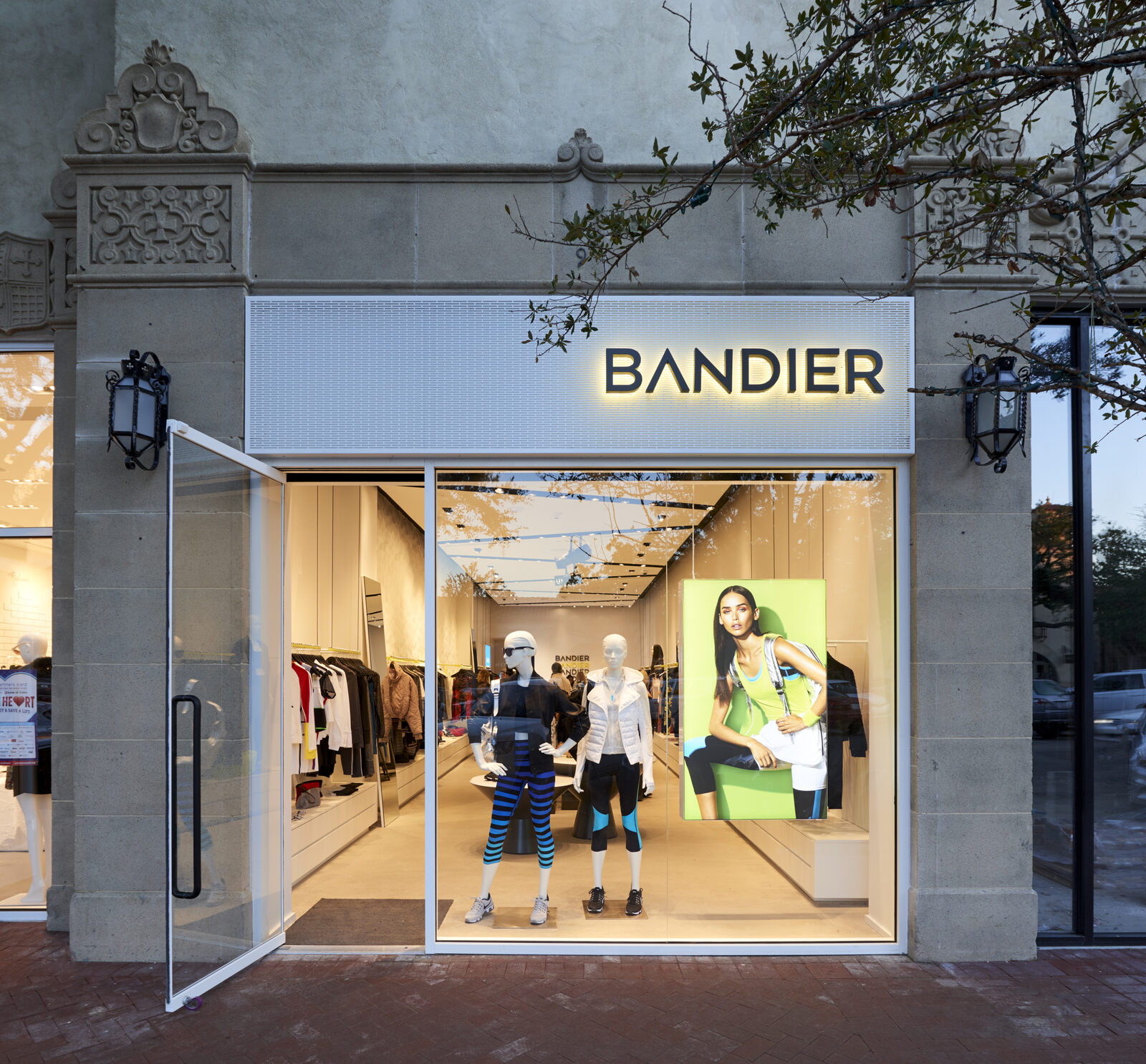 Bandier Dallas storefront with an illuminated Bandier sign, glass windows, mannequins, and activewear displays.